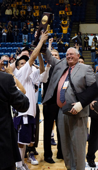 Coach Steve Fritz and Tyler Nicolai hoist the NCAA Division III men's basketball national championship trophy.
