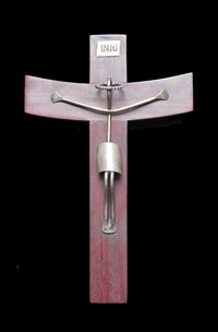 This small crucifix was made in Mexico in the early 21st century.  It is made of bent silver and cherry wood.