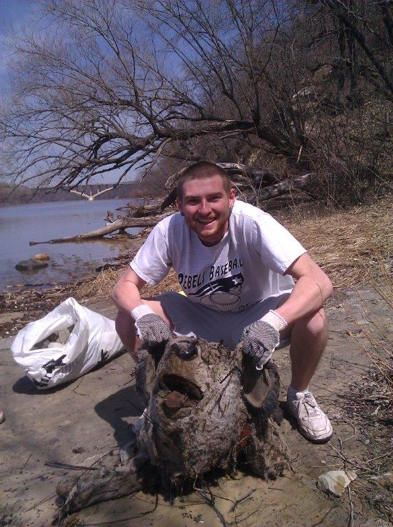 A volunteer poses with a severed stuffed bear found along the Mississippi River last year.