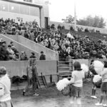 The mascot and cheerleaders in 1969. Note also the dirt track.