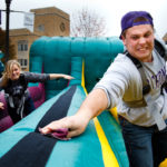 Freshmen Ashley Zweber and Michael Fritz engage in some inflatable competition during homecoming Purple on the Plaza events Oct. 13. (Photo by Mike Ekern '02)