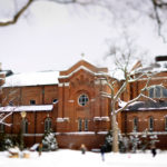 A snow-covered Chapel of St. Thomas Aquinas is seen through tree branches March 5, 2013. The circular window on the side of the chapel is highlighted through the use of a tilt-shift lens.