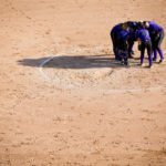 The Tommies huddle during a softball game against Macalester College on April 25, 2013. (Photo by Mark Brown)