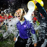 St. John Vianney head coach Nathanial Binversie gets a victory shower from his team during the 14th annual Rectors' Bowl on Sept 28 in O'Shaughnessy Stadium. The annual tradition, in which the graduate St. Paul Seminary "Sons of Thunder" take on the undergraduate  SJV seminary "JAXX", saw the undergrads take the cup 19-12. (Photo by Mike Ekern '02)