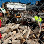 Workers sort through piles of Mankato Stone during the demolition of O'Shaughnessy Hall in 2010. (Photo by Mark Jensen)