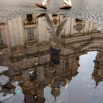 A man walks past the reflection of Saint'Agnes in Agone church in Piazza Navona.  (Mike Ekern/University of St. Thomas)