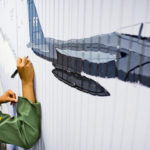 2nd Lt. William Mack '12 signs a section of an Air Force ROTC Detachment 410 mural. (Photo by Mark Brown)
