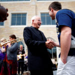Dease laughs with a student following the end of the ceremony. (Photo by Mike Ekern '02)