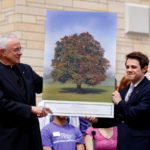 Dease and Undergraduate Student Government president Mike Orth hold a rendering of a blue beech tree that will be planted on the east side of the quadrangle in Dease's honor.(Photo by Mike Ekern '02)