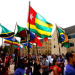Students carry international flags toward the podium. (Photo by Mike Ekern '02)