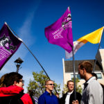 Students holding St. Thomas flags hang out on the John P. Monahan Plaza during the community lunch prior to the inauguration (Photo by Mark Brown)