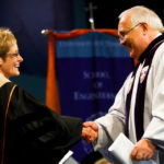 President Julie Sullivan shakes hands with trustee Ron Fowler. (Photo by Mark Brown)