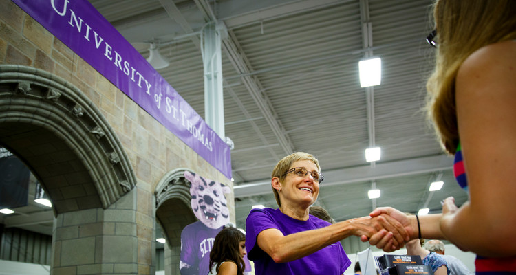 President Julie Sullivan greets a visitor at the university's Minnesota State Fair booth in August 2013.