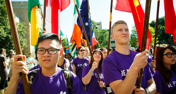 International students carry flags and walk during the annual March Through the Arches ceremony on September 2, 2014.