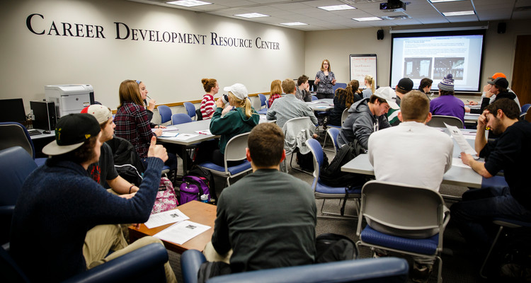 Career Specialist Amber Bieneck Thom (middle back) talks to students during a job and internship fair orientation event at the Career Development Center's Career Development Resource Center in the Murray-Herrick Campus Center on December 15, 2014. Students attended the event to learn about and register for the spring Job and Internship Fair.