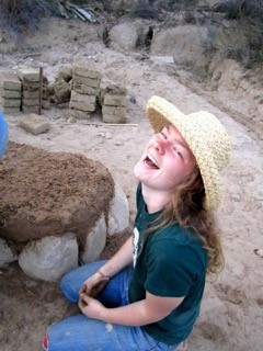 Meredith Heneghan ’16 sits next to the bench that she helped to build with the cob she mixed.