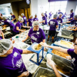 Volunteers pack prepared meals for Feed My Starving Children.
