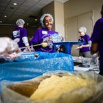 Student Zay Aden smiles as she readies a food bag.