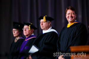Commencement speaker Archie Black, CEO of SPS Commerce, right, smiles during the graduate business commencement ceremony May 23, 2015 in the Anderson Athletic and Recreation Complex Field House.