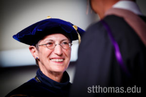 Opus College of Business Dean Stefanie Lenway smiles while handing out diplomas during the graduate business commencement ceremony May 23, 2015 in the Anderson Athletic and Recreation Complex Field House.