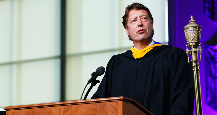 Archie Black, CEO of SPS Commerce, right, gives the commencement address during the graduate business commencement ceremony May 23, 2015 in the Anderson Athletic and Recreation Complex Field House.