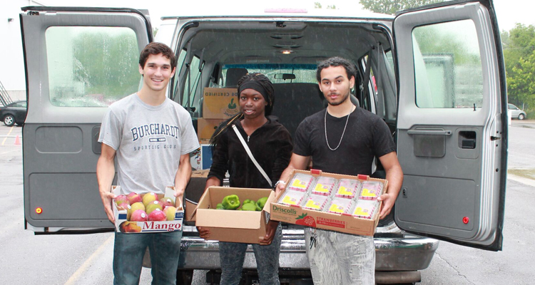 St. Thomas student Parker Hewes (left) stands with DeDe Fuller and Adam Pruitt, two high school students who work for Brightside Produce.