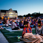 Students watch a movie on the O'Shaughnessy Stadium video screen.