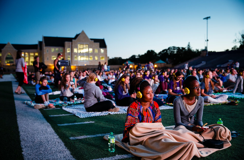 Students watch a movie on the O'Shaughnessy Stadium video screen.