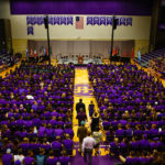 The platform party enters Schoenecker Arena to address incoming students during the opening welcome and blessing ceremony.
