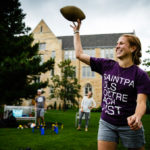 Megan Hastings throws a football on the Lower Quad during the Opening Celebration picnic.
