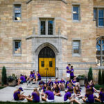 Students eat their food in front of Aquinas Hall during the Opening Celebration picnic.