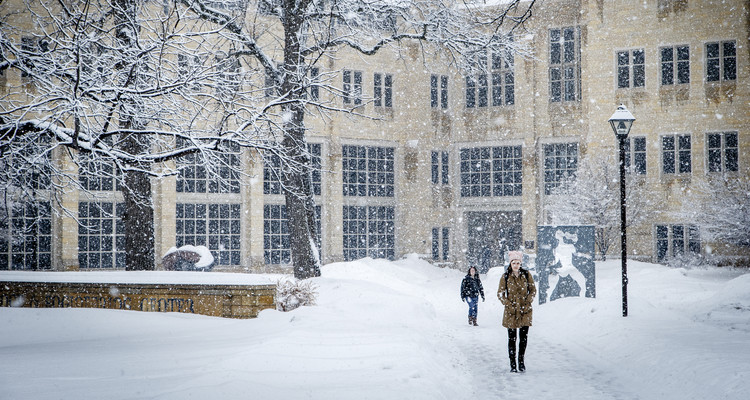 Students walk through the snow across Sabo Plaza on South Campus in front of Owens Science Hall and O'Shaughnessy Science Hall during a snow storm on February 20, 2014 in St. Paul.