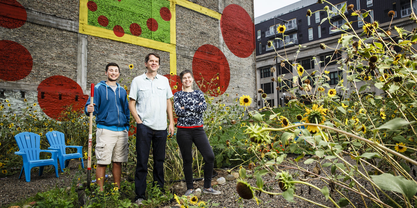 Left to right, Hunter Gaitan '15 (Biology), Biology Professor Adam Kay and Amanda Lovelee, St. Paul City Artist, pose for a portrait at the Urban Flower Field at Pedro Park at 10th and Robert Streets in downtown St. Paul on September 22, 2015. With the help of members of the downtown community, the project has planted 96 bio-diverse plots of flowers. University of St. Thomas researchers and students will use these plots to test whether more diverse flower plots are better able to extract harmful substances from the soil. The plots are arranged in a shape representing the golden mean, creating walking paths and a gathering space for programmed activities and neighborhood events.