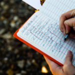 A student takes notes in a log book.
