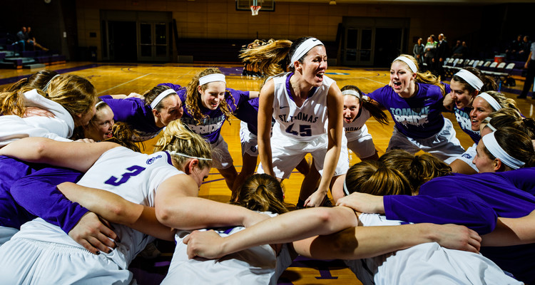 Kaitlin Langer and the Tommies psych up before a women's basketball game versus Gustavus Adolphus College.