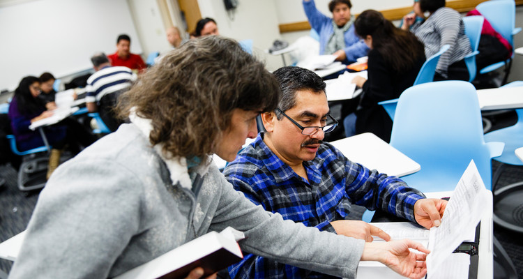 Theology professor Anne Attea helps a student during a Hispanic Lay Ministry class. Photo by Mike Ekern '02.