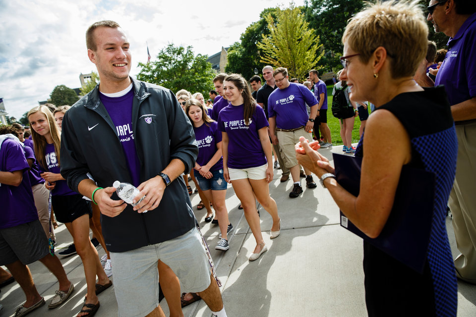 A student talks to president Julie Sullivan as he processes across the Lower Quad September 8, 2015 during the March Through the Arches, an annual ceremony where incoming freshmen are welcomed to campus.