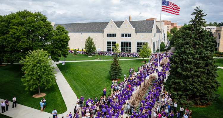 Incoming freshmen walk through the lower quad as faculty, staff and fellow students cheer them on during the March Through the Arches ceremony on September 8, 2015.