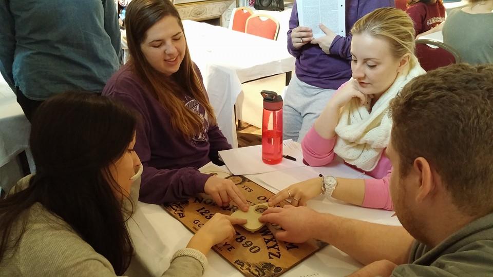 Classmates in the 2015 J-Term course "Spooks, Psychics and Skeptics in the UK" experiment with a Ouija board. (Photo courtesy of Greg Robinson-Riegler)