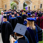 New faculty receive applause as they walk past The Arches at the academic convocation procession