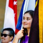 International students hold the flags of their home countries.