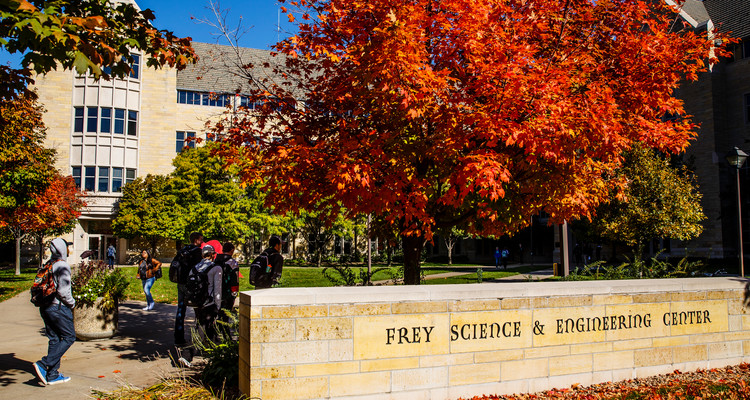 Students walk across south campus in front of O'Shaughnessy Science Hall in front of the Frey Science & Engineering Center sign on a sunny autumn day on October 13, 2016.