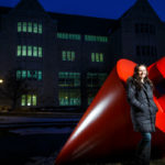 Engineering major Lauren Vallez poses for a portrait next to "The Plunge" sculpture on south campus near the Frey Science and Engineering Building. Photo by Mark Brown.