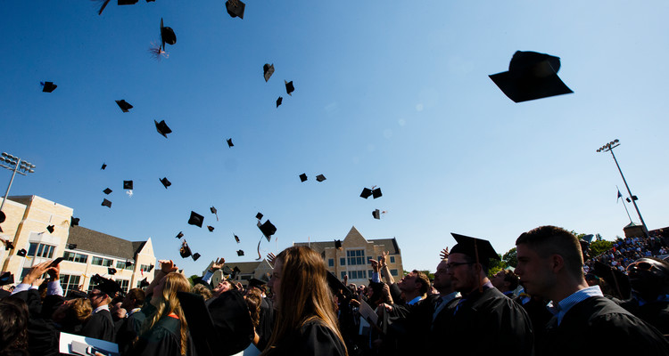 Students toss their caps in the air at the 2016 undergraduate commencement ceremony at O'Shaughnessy Stadium on May 21, 2016 in St. Paul.