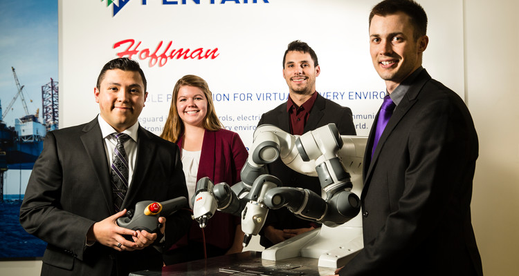 From left, Luis Chavez (Mechanical Engineering), Claire Dunford (Mechanical Engineering), Gabriel Swanton (Electrical Engineering) and Joe Allison (Mechanical Engineering) pose with their Spring Senior Design Team for Pentair on February 9, 2017, in Anoka at the Pentair Anoka location. The Pentair team worked on building a table for a robotic tool and designed software for the robot to use in a manufacturing process.