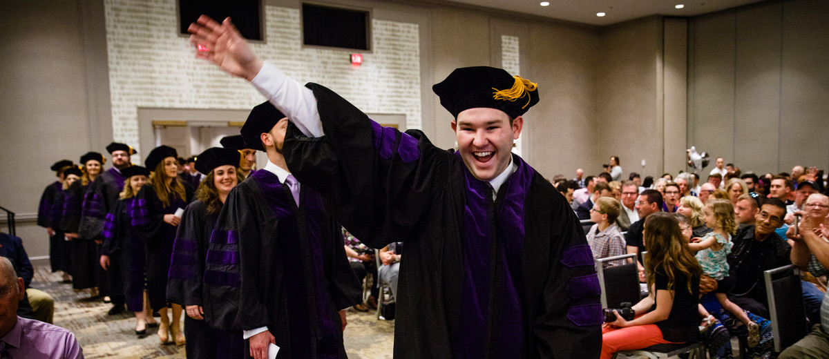 A student waves to family members during the School of Law Commencement ceremony May 13, 2017 at the Minneapolis Hilton.