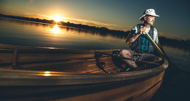 Communication and Journalism professor Mark Neuzil poses in his handmade wooden canoe September 30, 2016 on Lake Nokomis in Minneapolis.