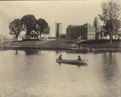 The campus of the St. Thomas Aquinas Seminary, later called College of St. Thomas, can be seen behind Lake Mennith in 1886. The original property for St. Thomas was donated by the Finn family.