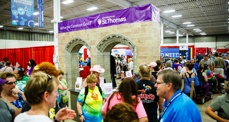 Fairgoers walk past at the University of St. Thomas booth with replica Arches in the Education Building at the 2016 Minnesota State Fair on August 25, 2016.