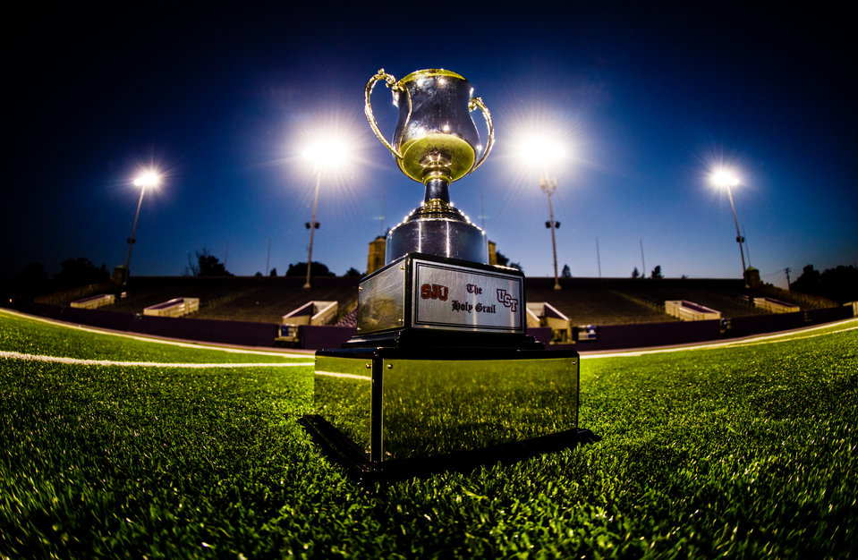 The Holy Grail trophy, the prize for winning the Tommie-Johnnie football game, is shown at night on the grass of Palmer Field inside O'Shaughnessy Stadium. Objects in the background and the reflection of the photographer have been removed in PhotoShop.